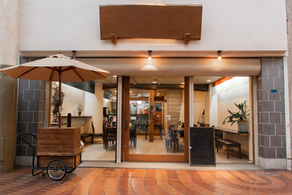 Front view of a Japanese restaurant with large windows showcasing modern and minimalist interior design